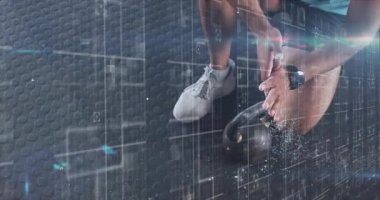 Spor salonunda tebeşirin içine elini daldıran adam kettlebell eğitimine rehberlik ederken toz üretiyor. Sporcu, antrenman, fütüristik, ekipman, fitness, teknoloji, performans