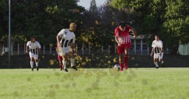 Futbolcu orta sahada top sürüyor defans oyuncusundan kurtuluyor kayıyor ve çim püskürtüyor. Sporcular, yarışma, çeviklik, spor, aksiyon, açık hava, takım çalışması