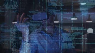 Yetişkin bir erkek müteahhit masasında VR kulaklığı etkinleştiriyor, konfigürasyon için kod aşırıyor ve aşırıyor. Fütürist, sürükleyici, dijital, yenilik, teknoloji, çalışma alanı, arayüz