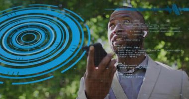 Olgun adam akıllı telefon kaldırıyor, komut veriyor, ses asistanı teknolojisini gösteren bir kod oluşturuyor. Teknoloji, yenilik, fütüristik, kentsel, yaşam tarzı, iletişim, dijital