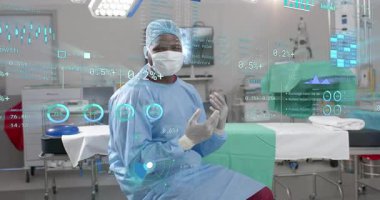 Yetişkin bir cerrahın eldivenli ellerini kaldırması ameliyathanede izlenmek üzere holografik sağlık tablolarını başlatıyor. Tıbbi, teknoloji, fütüristik, yenilik, sağlık, analiz, görselleştirme