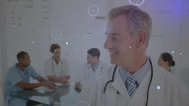 Doktor meslektaşlarına doğru dönüyor, tıbbi düğümleri aktive ediyor ışık çizgileriyle ekibi birbirine bağlıyor. İşbirliği, takım çalışması, sağlık, profesyonel, teknoloji, yenilik, analiz