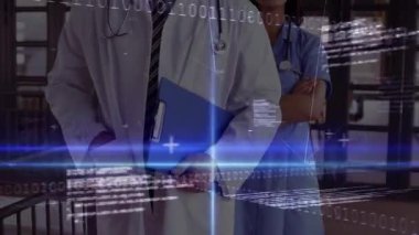 Doktor ve hemşire ışık çubuğunu izliyorlar. İkili akımlar başlatıyorlar ve sağlık verilerini gösteren ağ çizgileri var. Teknoloji, sağlık, işbirliği, yenilik, tanı, analitik, fütüristik