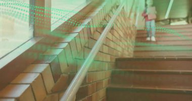 Öğrenci çocuk merdivenlerde sırt çantasıyla beliriyor, merdivenlerden iniyor ve eğitim için pencereye el sallıyor. Kentsel, minimalist, enerjik, genç, iyimser, mimari, doğal ışık