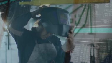 Kaynak kayışı, kaynakçı kaskı otomotiv asansörünün altında şifreleme akışlarıyla hazırlıyor. Sanayi, zanaat, güvenlik, teknoloji, güç, hassasiyet, mekanik