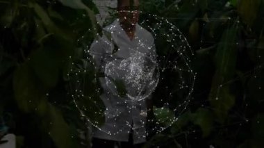 Çiftlik serasında botanikçi, asmaları dijital küre olarak inceleyip verileri izliyor. Botanik, teknoloji, yenilik, araştırma, sürdürülebilirlik, bilim, tarım