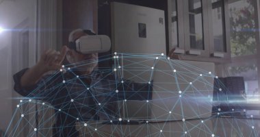 VR kulaklık takan ve ekose gömlekli olgun bir adam mutfakta dizüstü bilgisayarla el kol hareketi yapıyor. Teknoloji, yenilik, bağlantı, dijital, modern, iç, üretkenlik