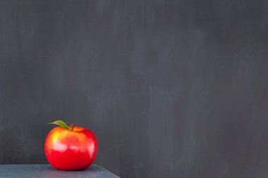 Tahtanın önünde kırmızı elma