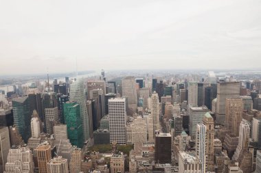 Düz tasarım kentsel gökdelenler, bulutlu gökyüzünün altında çatı su tankları yer alıyor. Mimari, modern, kurumsal, metropol, kentsel, yapısal, ufuk çizgisi