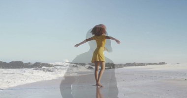 Kumsalda okyanusa bakan sarı elbiseli kadın ıslak kum, okyanus dalgaları, kayalık çıkıntılar. Romantik, dinginlik, yansıma, doğal, özgürlük, iyimserlik, sükunet