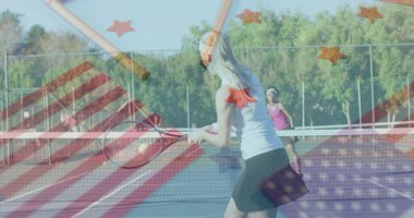 Sallanan oyuncu tenis kortuna raket, top ve bayrak kaplamalarıyla ters vuruş yapıyor. Atletizm, rekabet, spor, açık hava, canlı, takım çalışması, motivasyon