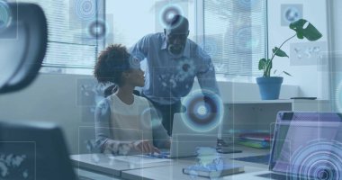 İşbirlikçi yönetici ve meslektaşım ofis masasındaki dizüstü bilgisayarlarda saksı bitkisi ile birlikte verileri inceliyor. Profesyonel, takım çalışması, kurumsal, modern, analitik, dijital, çalışma alanı