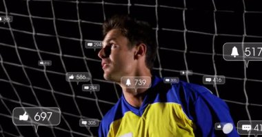 Kalecinin dalışının etrafında yüzen sosyal medya ikonları oluşturan, geceleri futbol topunu koruyan bir çerçeve. Sporcu, dijital, modern, spor, aksiyon, dinamik, rekabet