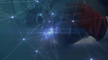 Eldivenli el, kavrayan metal halkaya ulaşıyor. Parlayan eldiven, incelenmek üzere titreşiyor. Teknoloji, mühendislik, yenilik, makine, dijital, endüstriyel, atölye