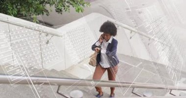 Profesyonel iş adamı basamaklara çıkıyor. Tote ve hokkabazlık yapıyor. Telefon kontrolü yapıyor. Kentsel, profesyonel, modern, moda, yaşam tarzı, güven, hareketlilik