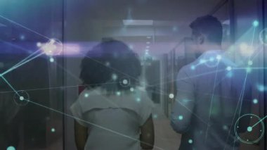 Ağ analisti veri merkezi raflarını işaret ediyor. Bilgi işleme tabletini takip ediyor. Çıkışta zayıflıyor. Teknoloji, veri, dijital, siber güvenlik, yenilik, bağlantı, şirket