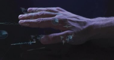 Adamın sağ eli, reaksiyonlar ve veri analizi için kaydırma kodlarıyla hologram haritasını aktifleştiriyor. Holografi, arayüz, fütüristik, teknoloji, veri görselleştirme, dijital, siber