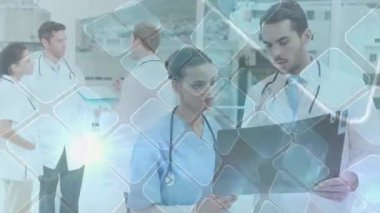 Hemşire radyografiyi tutuyor ve doktor tıbbi inceleme için ince ağ örtüsünü başlatıyor. Tıbbi, takım çalışması, işbirliği, yenilik, klinik, teknoloji, sağlık hizmetleri