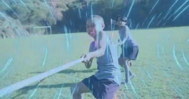 İp yakalayıp ot çeken üç çocuk spor müsabakasını kazanmak için beşlikle kutlama yapıyor. Oyun, takım çalışması, açık hava, canlı, arkadaşlık, aktivite, rekabet