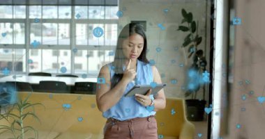 Tabletli bir ofis çalışanı, sürüklenen sağlık simgelerini çalıştırırken, tararken, sonra ufuk çizgisini yansıtırken. Fütürist, profesyonel, gösterişli, yenilikçi, analitik, düşünceli, kentsel