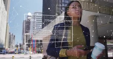 Kadın elinde kahve ve akıllı telefon tutarak şehirde yürüyor. İç görü için veri panellerini çalıştırıyor. Kentsel, teknoloji, profesyonel, veri görselleştirme, çağdaş, yenilikçi, kurumsal