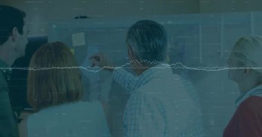 Adam cam tahtaya basıp işaret ediyor, proje planlaması için yapışkan notları işaretliyor ve hareket ettiriyor. İşbirliği, beyin fırtınası, takım çalışması, strateji, ofis, iletişim, yenilik