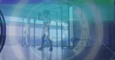 Erkek sporcu Kettlebell 'i kaldırırken spor salonunda HUD' u etkinleştirirken güç antrenmanı için aşağı sallanıyor. Zindelik, güç, egzersiz, dijital, modern, dinamik, atletizm