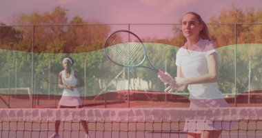 Pembe etekli oyuncu kil sahada dönen topu raketlerle, ağ ve tel örgülerle, kopyalama alanıyla. Spor, rekabet, açık hava, aktif giysi, atletik, enerjik, kararlı.