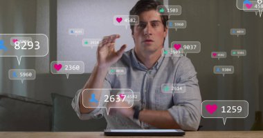 Gri gömlekli bir adam ofiste oturmuş tabletle etkileşime geçiyor, yüzen bildirim simgeleriyle. Teknoloji, veri, dijital, çalışma alanı, iletişim, modern arayüz