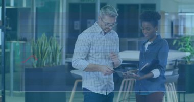 Ofiste günlük iş kıyafetleri içinde dijital tablet inceleyen iki iş arkadaşı, grafikle örtüşüyor. İşbirliği, takım çalışması, veri analizi, modernlik, profesyonel, teknoloji, üretkenlik