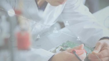 Elektronik teknisyen demir ucunu bordaya getiriyor ve ağ yoğunlaşırken lehim kablosunu besliyor. Teknoloji, yenilik, devre, mühendislik, kesinlik, bağlantı, laboratuvar