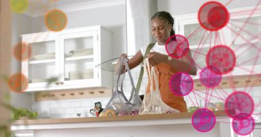 Mutfağa giren kadın çantalarını taşırken ve çantalarını açarken yemek hazırlığı yapıyor. Minimalist, yaşam tarzı, modern, yerli, rahat, düzenli, enerjik