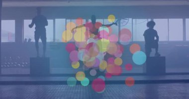 Orta atlet boks atlayışlarını başlatıyor ve renkli dairelerle senkronize spor salonu çalıştırıyor. Fitness, antrenman, güç, çeviklik, egzersiz, takım, motivasyon