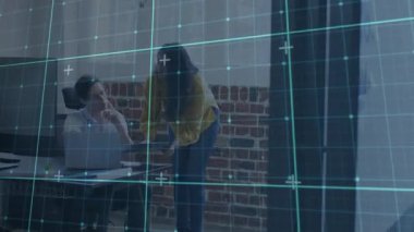 Bilgisayarın yanına dizüstü bilgisayarı yerleştiren solgun Hintli kadın teknik inceleme sırasında meslektaşına rehberlik ediyor. Teknoloji, işbirliği, modernlik, profesyonellik, yenilik, çalışma alanı, iletişim