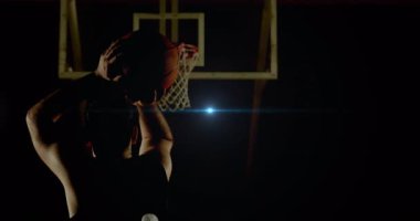 Basketbolcu, potanın arkasında parlamadan ve şut atmadan önce topu alçaktan tutuyordu. Sporcu, hareket, siluet, yoğunluk, atletizm, antrenman, yarışma