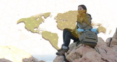 Zirvenin duruşunu ayarlayan kadın, teknolojik planlama için hareketli dünya haritasını tetikliyor. Macera, keşif, bağlantı, açık hava, yenilik, ilham, dayanıklılık