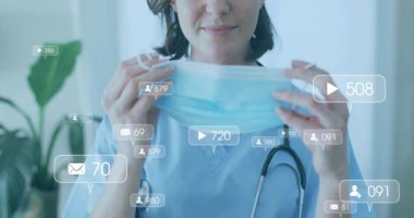 Sağlık uzmanı, nişan ikonları yükselirken klinikteki cerrahi maskeyi kaldırmaya çalışıyor. Tıbbi, profesyonellik, hijyen, sağlık, dijital, iletişim, sağlık