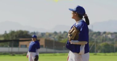 Gökyüzüne bakan beyzbol atıcısı tümseğe çömelmiş, girdap oluşturarak yorgunluğunu ifade ediyor. Atletizm, takım çalışması, kararlılık, spor giyimi, dinamik, açık hava, enerji