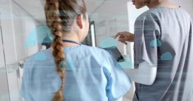 Hemşireler, meslektaşlarıyla birlikte hasta verilerini incelerken canlandırılmış simgeleri etkinleştiren tabletleri tıkırdatıyor. İşbirliği, sağlık, dijital, takım çalışması, profesyonel, modern, iletişim