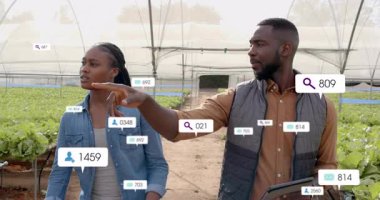 Tünelde yürüyen ve ekin verilerini işaret eden bir adam, meslektaşları kafa sallarken ve dijital ölçümler artarken. Tarım, teknoloji, veri görselleştirme, takım çalışması, sürdürülebilirlik, hassasiyet tarımı, modern