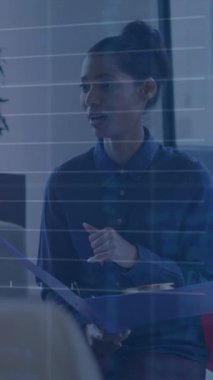 Animation of financial data processing over diverse business people in office. Global business, finances, computing and data processing concept digitally generated video.