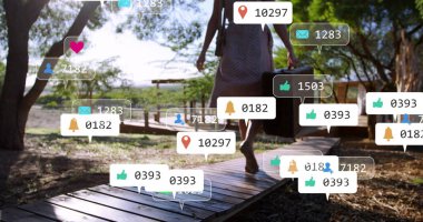 Yürüyen kadın, yaz elbisesi içinde sosyal simgelerle sahil yolunda bavul tutuyor. Tatil, tatil, sıcaklık, huzur, kırsal, açık hava, yaşam tarzı.