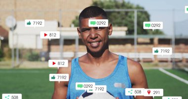 Sosyal medya ikonlarıyla futbol sahasında elinde futbol topu tutan mavi kolsuz erkek. Atletik, spor, açık hava, takım çalışması, fitness, canlı, dijital