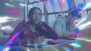 Genç kız, pembe-mavi ışık örtüsünü çekerken sınıfta yazı yazmayı bırakıp ilham arıyor. Öğrenci, eğitim, sınıf, odaklanma, konsantrasyon, öğrenme, gençlik