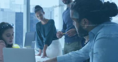 Bir grup insan dizüstü bilgisayarlarla bir masanın etrafında toplanmış bir şeyler tartışıyorlardı. Modern iş yerini ve yaratıcı işbirliği kavramını temsil etmek için tasarlandı..