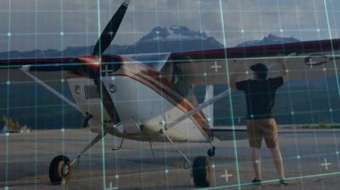 Pilot göl kenarındaki rampada yüksek kanatlı bir uçağa yaklaşıyor. Kereste teftişi ve güvenlik için kokpiti kontrol ediyor. Havacılık, macera, açık hava, seyahat, manzara, keşif, güvenlik