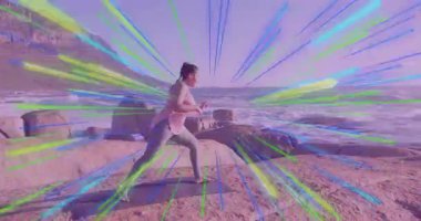 Kadın yoga minderini okyanusun kenarına yerleştiriyor ve Savaşçı II pozuna kayıyor. Fitness, farkındalık, sağlık, açık hava, dinginlik, denge, meditasyon