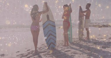 Güneşli ve dalgalı kumlu sahil şeridinde, mayo giymiş arkadaşlarımız sörf tahtası tutuyorlar. Sahil, sahil, tatil, yaz, açık hava, yaşam tarzı, hayat dolu.