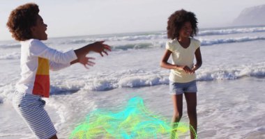 Kumlu ve güneşli bir günde okyanus dalgaları sıçratan kız ve oğlancılık oynuyorlar. Çocukluk, rahatlık, canlılık, sükunet, açık hava, aile, hayat dolu.