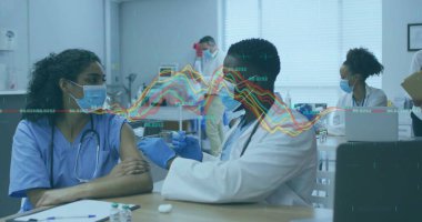 Mavi önlüklü hemşire şırınga şişesiyle klinikteki doktordan aşı enjeksiyonu alıyor. Tıbbi, sağlık, aşı, klinik, profesyoneller, laboratuvar, klinik